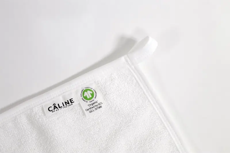 CÂLINE washcloth label with the GOTS organic certification tag